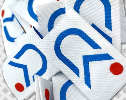Gewebte Labels mit modernem blau-rotem Logo auf weißem Hintergrund
