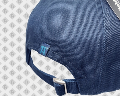 Dunkelblaue Cap mit hellblauem gewebtem Loopfold-Label „1A“ und verstellbarem Verschluss.