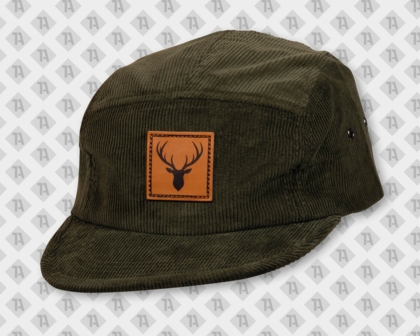 Dunkelgrünes Cord-Cap mit einem braunen Lederaufnäher und Lasergravur eines Hirsches mit Geweih