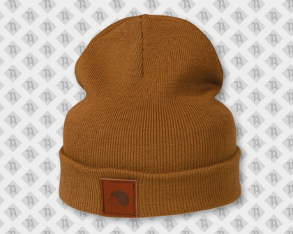 Okerfarbener Beanie mit einem dunkelbraunen Lederaufnäher und Lasergravur - Motiv: Igel-Logo