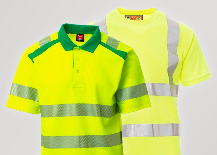 Zwei neongelbe Warnschutz-Shirts mit reflektierenden Streifen stehen vor hellem Hintergrund nebeneinander.