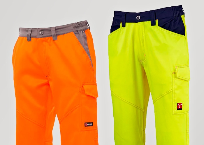 Zwei lange Warnschutz-Hosen in Orange und Gelb stehen vor hellem Hintergrund nebeneinander.
