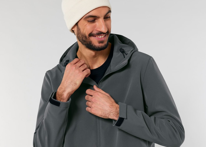 Mann in grauer Softshelljacke greift zum Reissverschluss.