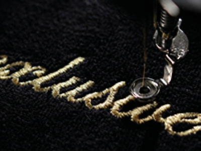 Stick auf Bluse Direktstick in metallic gold Werbeträger Motiv Veredelung Logo Stick-Kunst