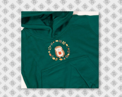 Eindunkelgrüner Kinder-Hoodie der mit einem DTF-Motiv "Igel mit Herbstkranz" bedruckt worden ist