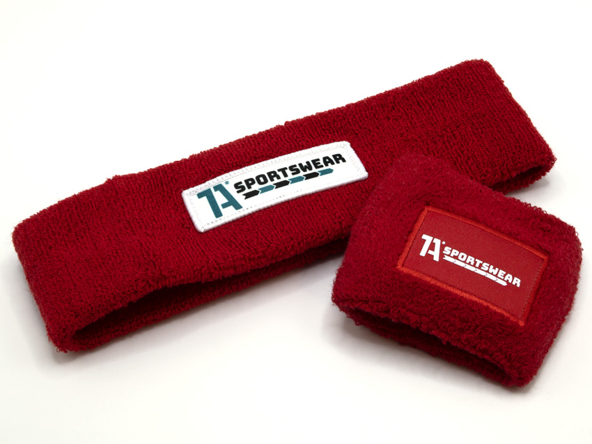 Ein rotes Stirnband und ein rotes Schweißband mit dem 1A Sportswear-Logo als Aufnäher und einmal als DTF-Druck